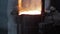 Industrial worker in protective gear pours molten metal at steel foundry. Furnace casting process, hot liquid steel flow