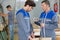 Industrial workers using protractor at factory workshop