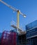 Industrial yellow crane and scaffolding on building site against blue sky