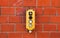 Industrial yellow switch box with power on and off switches buttons and key lock installed outdoors on a red brick wall from wareh