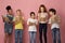 Industrious diverse pupils reading books, getting ready for school over pink background