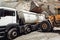 Industry details - industrial machinery working. Wheel loader loading gravel into dumper trucks. Transportation details