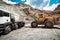 Industry details - machinery working. Wheel loader loading gravel into dumper trucks