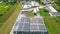 Industry with low carbon footprint. Industrial warehouses with solar panels on the roof. Technology park and factories from above