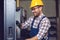 Industry Worker entering data in CNC machine at factory.