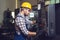 Industry Worker entering data in CNC machine at factory.