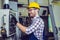 Industry Worker entering data in CNC machine at factory.