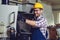 Industry Worker entering data in CNC machine at factory.