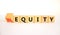Inequity or equity symbol. Turned wooden cubes and changed the concept word Inequity to Equity. Beautiful white table white