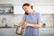 Inexperienced housewife holds saucepan in hands and calls asking for cooking advice