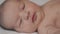 Infancy, childhood, development, medicine and health concept - close-up side view face of newborn awake baby