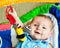 Infant baby boy playing on activity mat