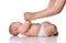 Infant baby girl kid in diaper is lying on her back start doing exercises to neck, torso lifts with adult coach