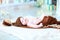 Infant baby lying on blanket in hat with bubo.