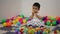 infant baby playing wooden block toy in playpen at home