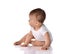 Infant baby toddler in white bodysuit has stopped crawling and sat on floor to look aside. Happy infancy concept