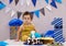 Infant boy`s first birthday cake smash Adorable baby smashing