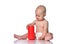 Infant child baby boy in diaper is sitting on the floor looking on a red cylinder in front of him, playing, touching