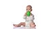 Infant child baby boy  in diaper and white shirt is sitting  with green ball toy in his hands, biting it on white