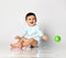 Infant child baby boy kid toddler in light blue body cloth sitting playing with green ball