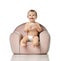 Infant child baby girl kid toddler in diaper sit in little armchair chair eat donut