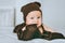infant child in brown knitted hat biting blanket