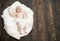 Infant covered with white blanket. Baby lying on soft duvet