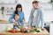 Infant girl mixing salad with metal spoons and mother& x27;s help