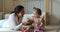 Infant girl play toy cubes with young latin woman babysitter