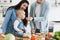 Infant girl tasting juicy tomato given by father in kitchen