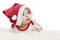 The Infant lies on his stomach in a Santa Claus hat with a surprised, funny face. New Year and Christmas celebration. Close-up.