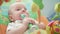 Infant playing baby rattle. Sweet baby face with toy. Adorable kid with rattle
