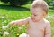 Infant playing with dandelions