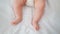 Infant's legs. The baby is lying on the bed and twitching his legs. Small feet. Newborn