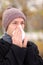 Infected man blowing his nose in tissue paper