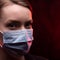 Infected woman in a medical mask on a black background. Isolation and quarantine, pandemic of the coronavirus. Infection of the