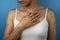 Infected woman with rash holding her hand on neckline