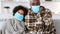 Infection outbreak. Sick African American family wearing protective masks, focus on thermometer in granddad`s hand