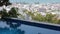 Infinity Pool Overlooks City Skyline - great view of colored houses and hotels, trees, sea and sky