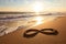 infinity sign on a sunlit beach, with waves rolling in the background