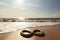 infinity sign on a sunlit beach, with waves rolling in the background