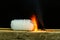 Inflamed plastic bottle filled with toxic smoke that burns and burns out leaving toxic smoke on a black background