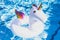 Inflatable colorful white unicorn at the swimming pool. Vacation time in the swim pool with plastic toys. Relaxation and