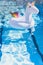 Inflatable colorful white unicorn at the swimming pool. Vacation time in the swim pool with plastic toys. Relaxation and