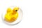 Inflatable mini yellow chicken or duckling on white plate on white background. Creative food concept, tobacco chicken. Flat lay