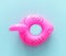 Inflatable pink flamingo ring over blue wooden background