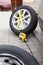 Inflating dismounted vehicle wheel after repairs, yellow tyre inflator connected with hose for work