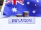 Inflation in Australia concept. Handwritten Inflation on a paper board, growing up arrow, coins and Australian flag in the
