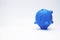 Inflation and devaluation concepts - Blue Piggy Bank against white wall background