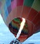Inflation process and preparation of hot air balloon at sunrise to fly in cloudy sky
